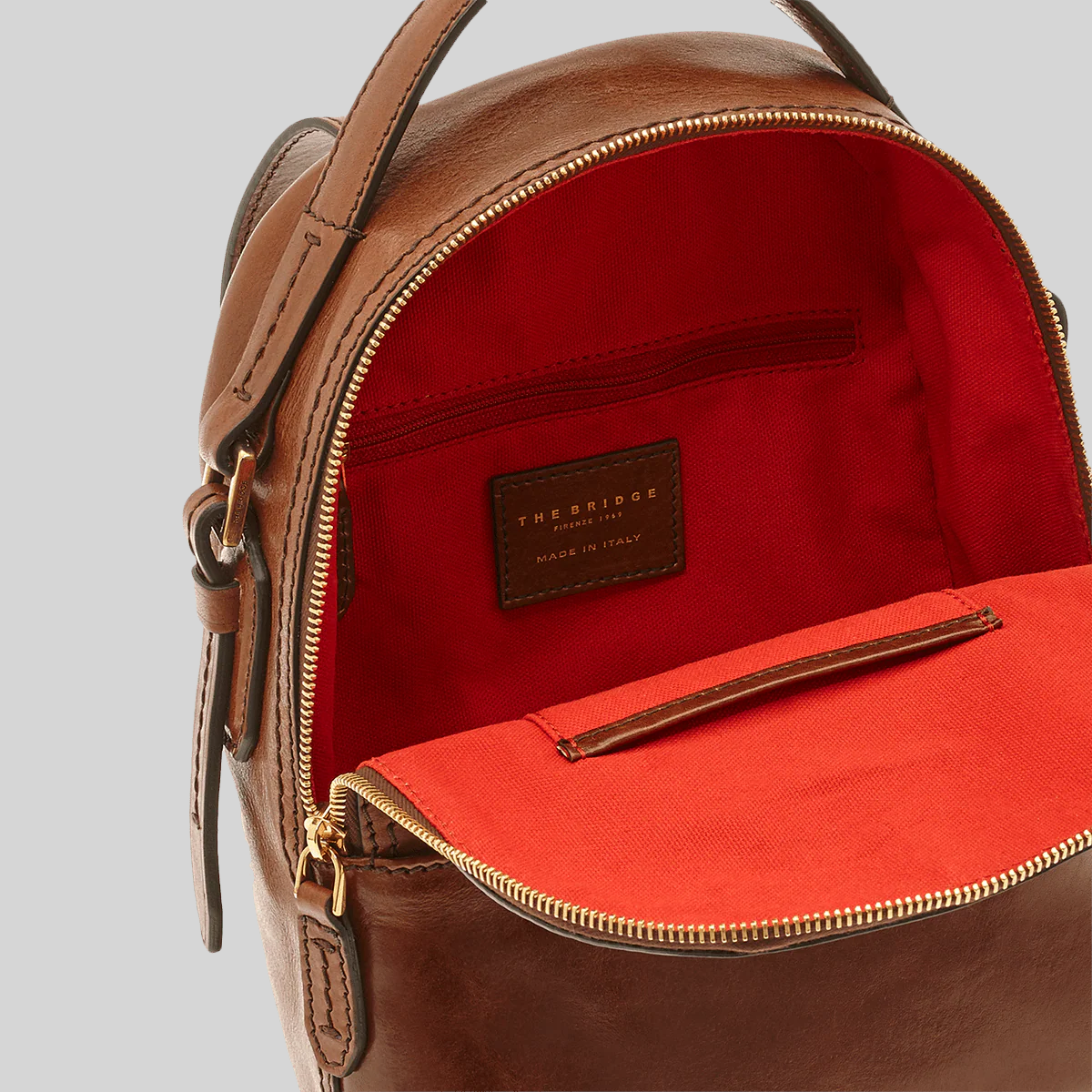 Zaino LIBUTTI in pelle marrone con interno foderato in tessuto rosso e chiusura a zip dorata