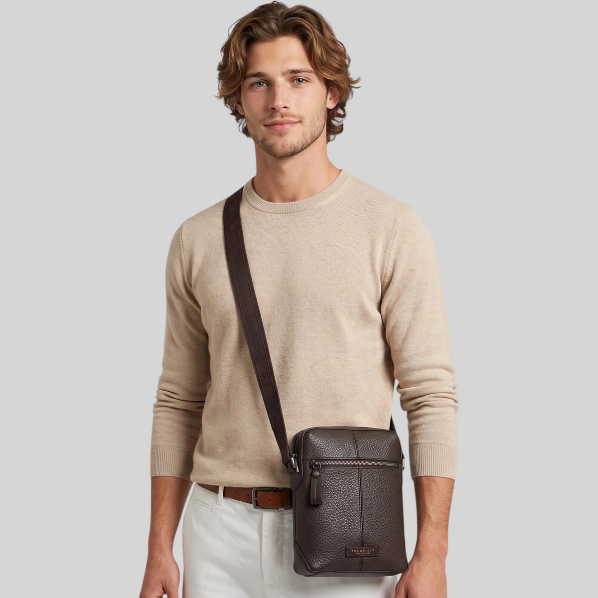 Modello indossa un borsello LIBUTTI in pelle martellata marrone con tracolla regolabile e chiusura a zip