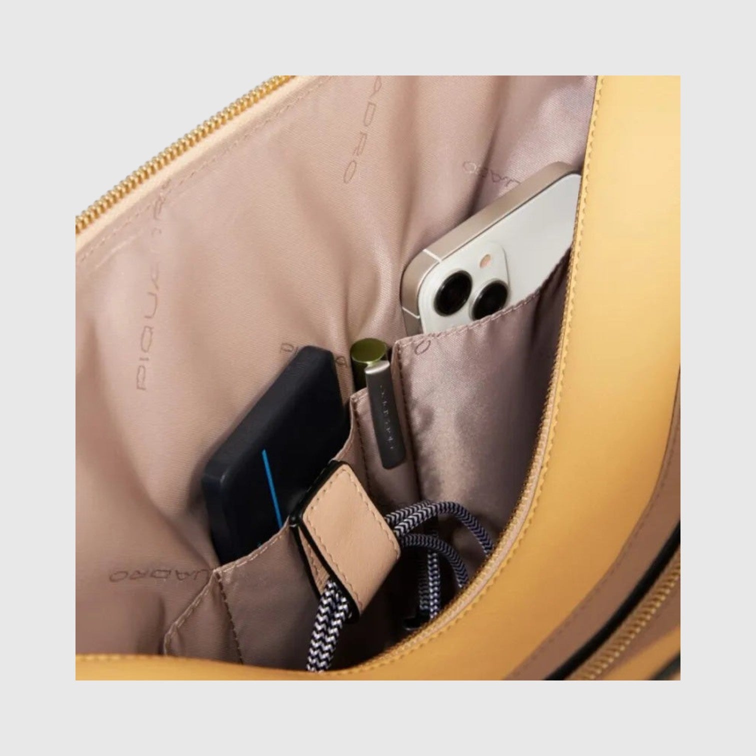 Interno della borsa professionale LIBUTTI con scomparti organizzati per smartphone, penne e accessori in pelle beige